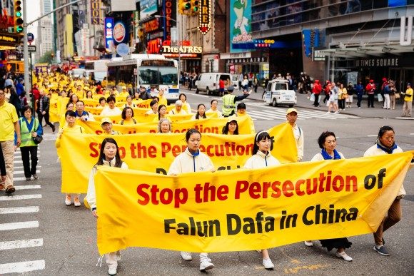 Practitioners march in New York behind banners reading Stop the Persecution of Falun Dafa in China